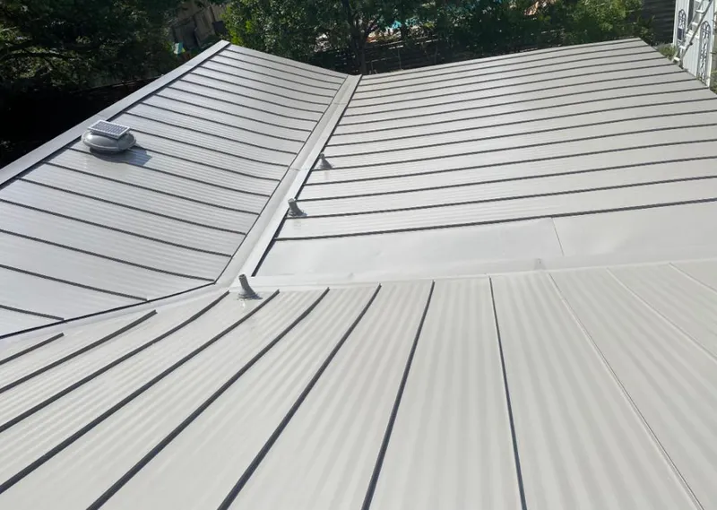 Solar attic fan installed on a metal roof for Roof Ventilation in Adel